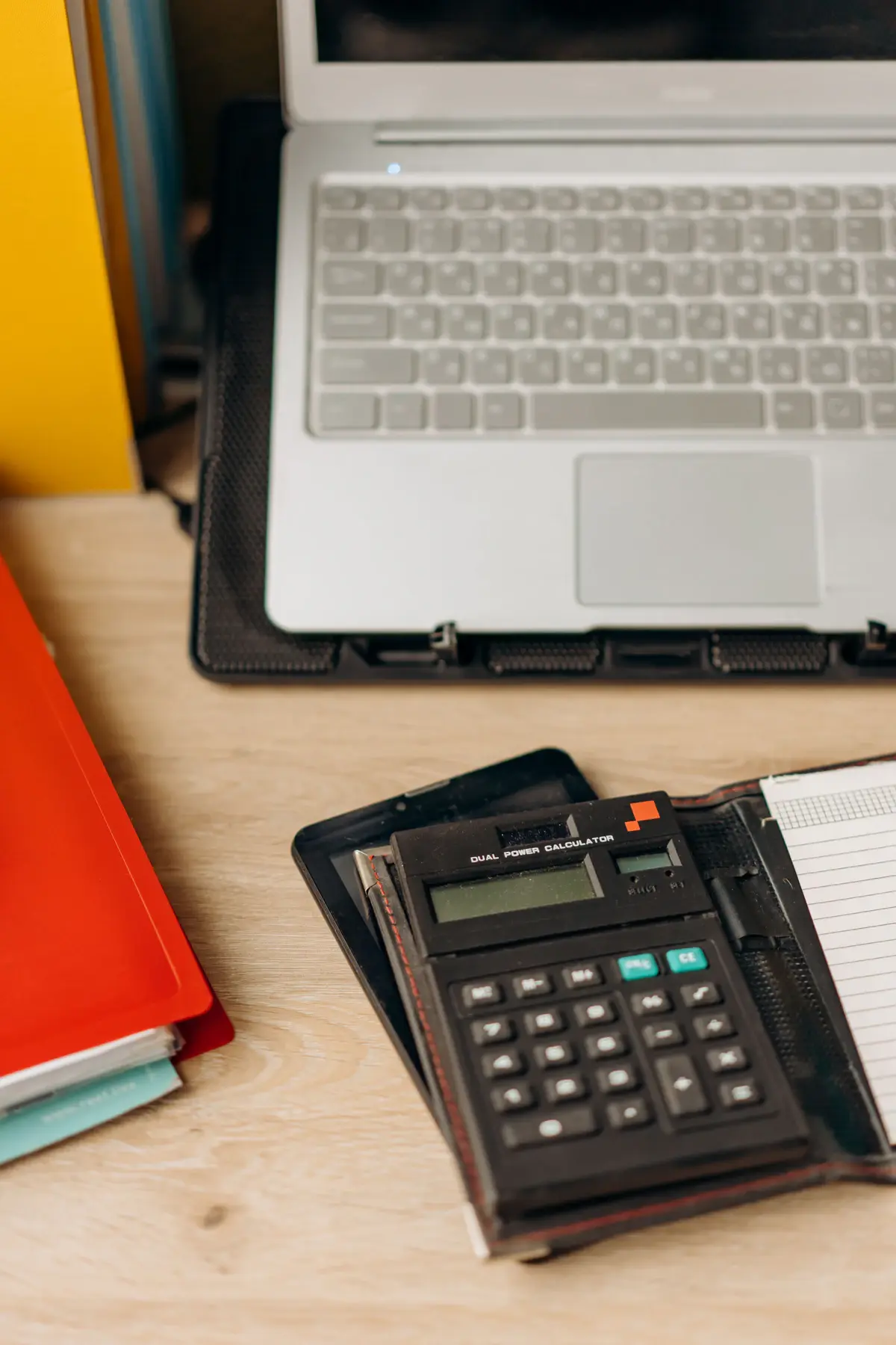 Calculatrice, ordinateur et documents utilisés pour préparer le budget d’un projet web