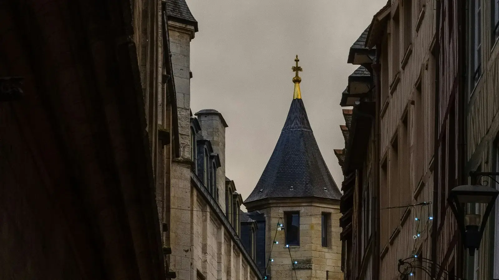 Rue historique du centre de Rouen menant vers une tour en pierre